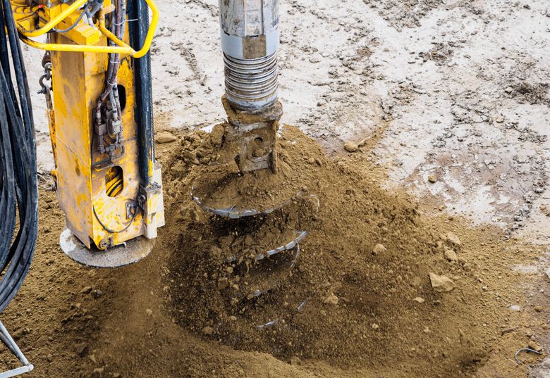 Drill bit boring into rock on a Comal County lot during a well re-drill