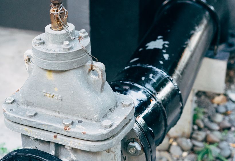 Capped wellhead valve and pipe fitting at ground level on a Comal County lot